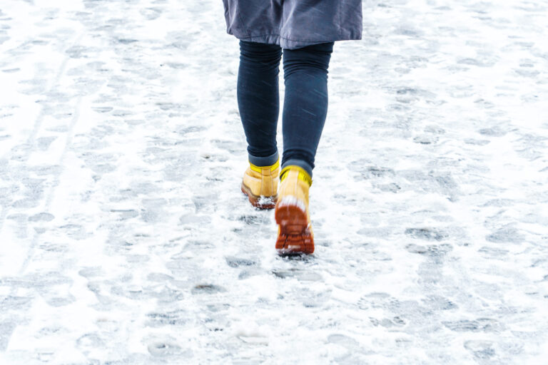 A woman is walking in snowy icy conditions