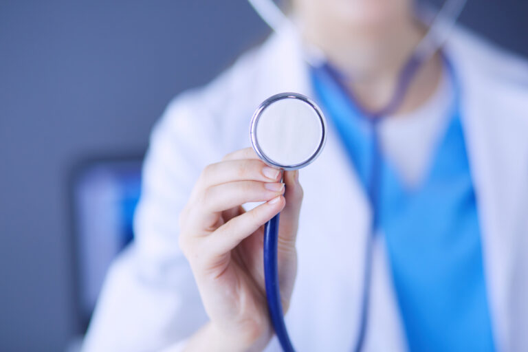 A doctor holding a stethoscope while giving negligent treatment. The patient may make an NHS complaint against them