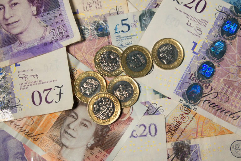 A pile of bank notes and pound coins to represent compensation in multiple injury claims.
