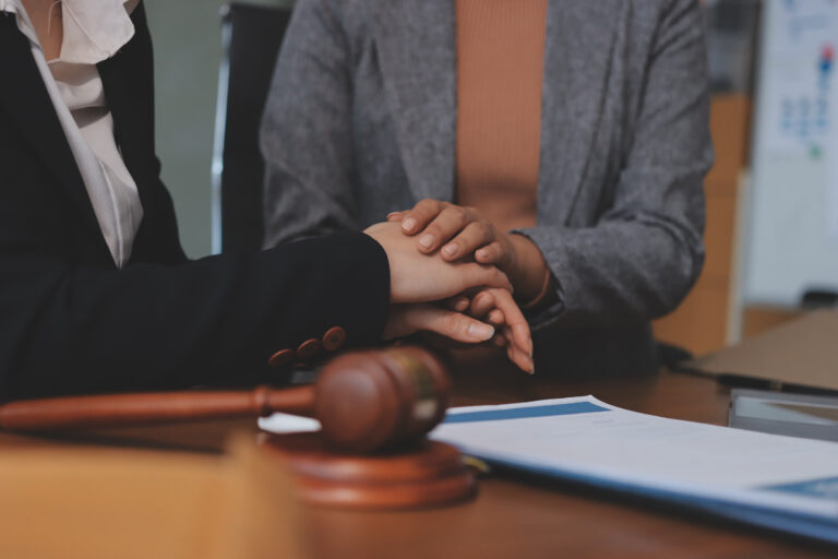 A multiple injury claims solicitor sat with a client at a desk with a gavel.