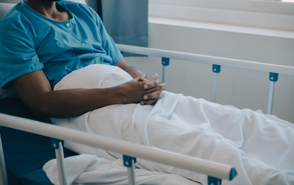 A man lying in hospital thinking about starting an A&E negligence claim after medical malpractice caused avoidable harm.