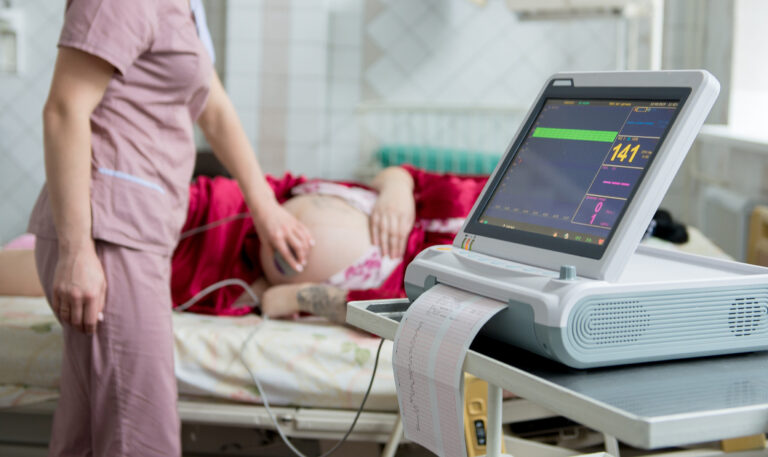 A pregnant woman receives a scan at a hospital
