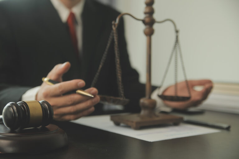 Specialised solicitor at a desk with scales and a gavel.
