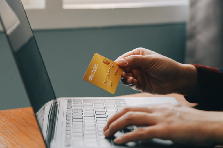 Woman using a credit card for online shopping to represent defective product compensation claims.