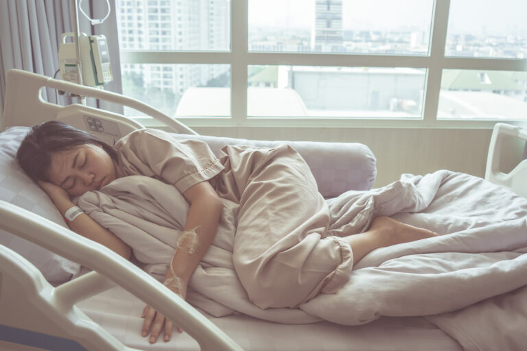 A woman lying in pain on a hospital bed due to internal organ injury