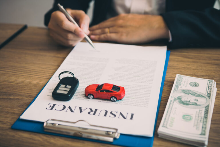A desk with a car and keys on top of legal expenses insurance papers