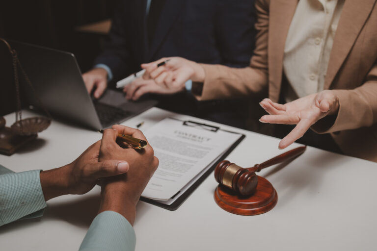 A solicitor answering a client's questions at their desk, like "What is negligence?".